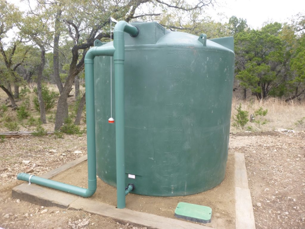 2500 gallon dark green Poly-Mart rainwater harvesting tank installation.